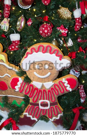 Artificial fir tree with Christmas decorations and gingerbread man. Close up. Christmas background