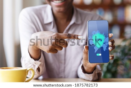 VPN App. Black Woman Pointing At Smartphone With Opened Virtual Private Network Application On Screen, African American Lady Enjoying Modern Technologies For Syber Security, Creative Collage, Closeup Royalty-Free Stock Photo #1875782173