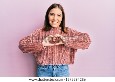 Young beautiful woman wearing casual clothes smiling in love doing heart symbol shape with hands. romantic concept. 
