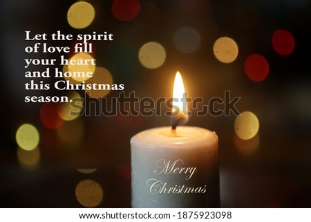 Merry Christmas card greeting with inspirational quote - Let the spirit of love fill your heart and home this Christmas season. On background of colorful bokeh lights and white candle on the table.