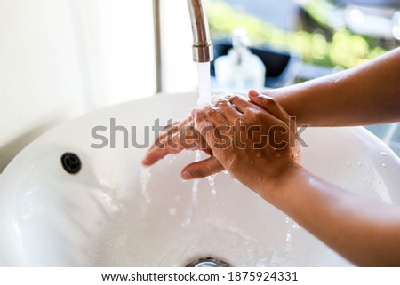 Men washing their hands in the sink, preventing the spread of COVID-19, a concept to prevent COVID-19.
