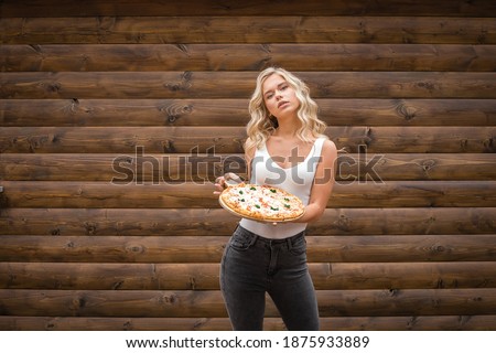 Cute girl holding a tray of pizza in her hands