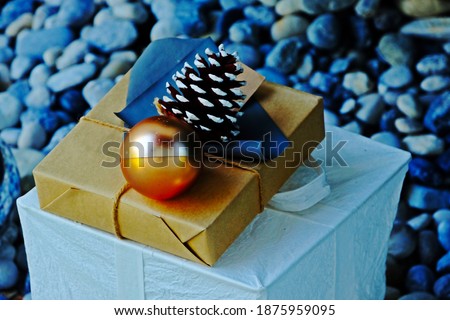 Christmas gift boxes collection with pine cone, pine tree and golden ball having blurred rock background. Christmas presents.