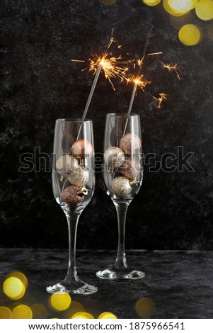 Abstract Christmas glasses with wine, champagne, bokeh lights on dark background