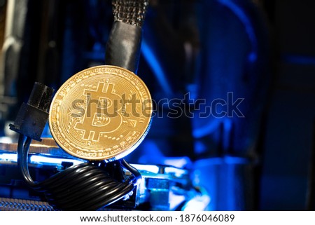 Bitcoin golden coins on a gpu with blue neon light. The future of money. 