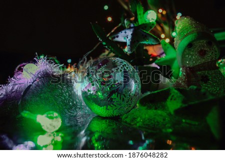 Little dishes and snowman decorated with snowflake and white Christmas balls on a rustic tree and glittering bright background
