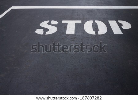 A white stop sign on a black road