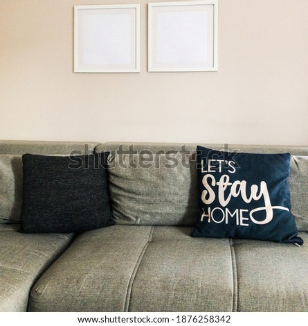 Let's stay home during quarantine. Empty frames above the sofa. Grey sofa and pillows.  