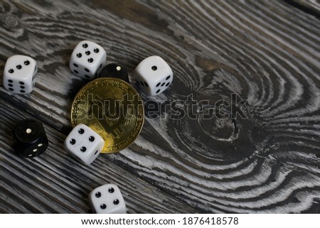 Bitcoin on black pine boards. Dice are scattered nearby.