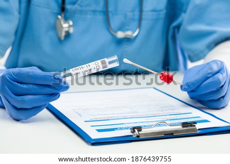Medical worker GP doctor holding swab sample collection kit,test tube for performing patient nasal swabbing,hand in blue gloves holding testing equipment,Coronavirus COVID-19 point of care diagnostic  Royalty-Free Stock Photo #1876439755