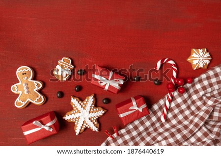 Set Festive New Year Biscuits, Gifts and Snowflake on Red Wooden Background