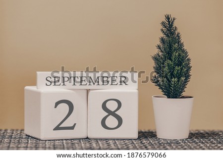 Desk calendar for use in different ideas. Autumn month - September and the number on the cubes 28. Calendar of holidays on a beige solid background.