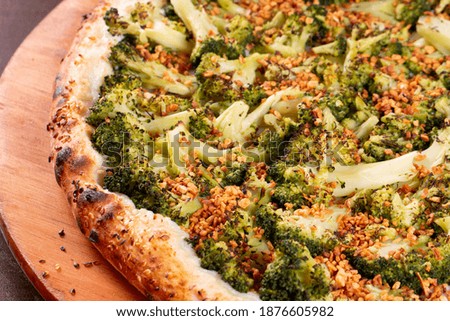 delicious broccoli pizza with garlic on wooden table