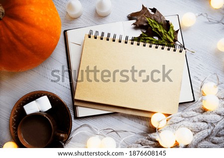 Winter Christmas decor. Celebration atmosphere. Warm colors, soft focus. Notepad with blank space for your inscription, top view. Christmas or winter planning concept.