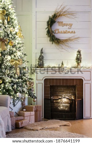 Winter celebrations at home. Vertical photo of comfortable living room with decorated fireplace, christmas presents under new year tree in modern apartment with cozy interior design