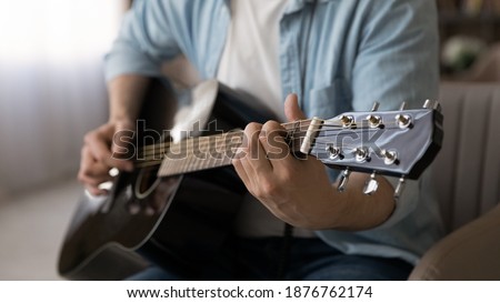 Wide banner panoramic view of male artist or composer hold play guitar at home studio. Man musician or singer use musical instrument, compose music or new song single. Hobby, entertainment concept. Royalty-Free Stock Photo #1876762174