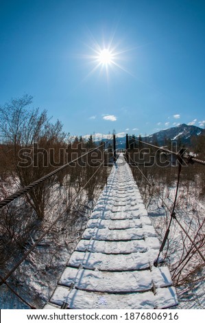 Suspension bridge in the winter mountains