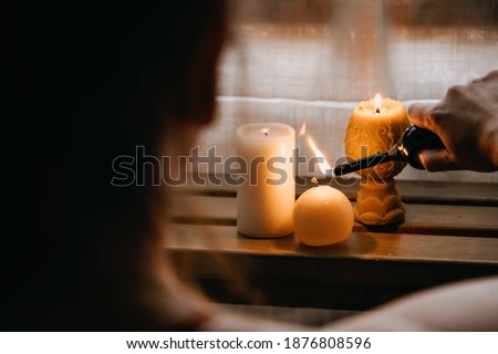 Young woman sitting on the floor, lights candles, enjoy meditation, do yoga exercise at home. Mental health, self care, No stress, healthy habit, mindfulness lifestyle, anxiety relief concept Royalty-Free Stock Photo #1876808596