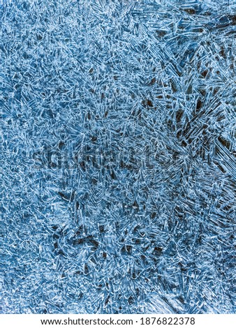 Ice texture. Blue winter background with water frozen by the cold. Vertical natural abstract background to use as a wallpaper or for your designs. Wintry.