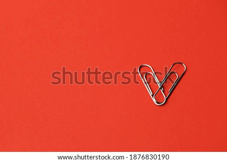 Heart shape paper clips on a red background. Valentine's day concept. High quality photo