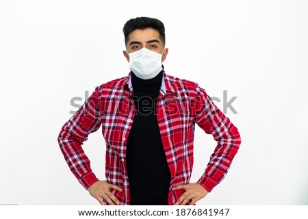 Young man wearing a checkered red shirt, wearing a white medical mask. Isolated White background.