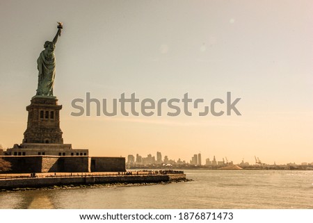 
STATUE OF LIBERTY  SUNSET WARM  MANHATTAN LANDSCAPE ORANGE NEW YORK CITY POWER AMERICA