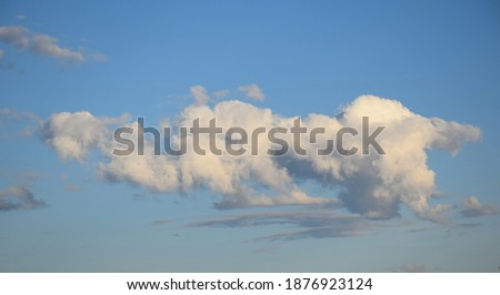 photo of a graphic resource of clouds against a blue sky with shadows created by the light of the sun