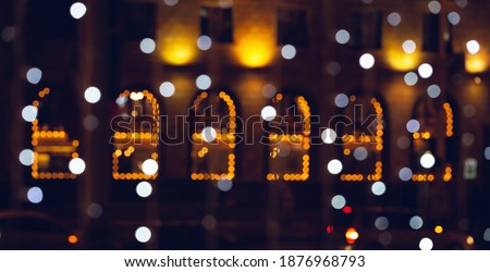 City lights defocused. Selective focus on Christmas decorations illuminated at night. Merry Christmas and Happy New Year card or banner with copy space