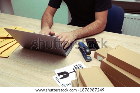 The man is preparing the parcels for packing and sending