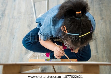Portrait of young Asian disabled child complex genetic disorders girl draw a picture with watercolor in element classroom