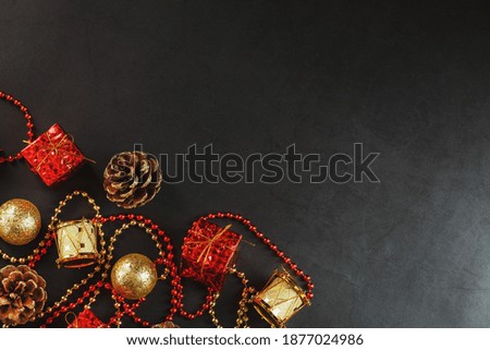 Christmas or New Years dark background with red and gold decorations for the Christmas tree with free space.