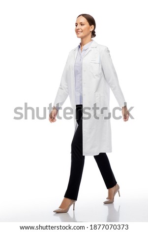 medicine, profession and healthcare concept - happy smiling female doctor or scientist in white coat walking Royalty-Free Stock Photo #1877070373