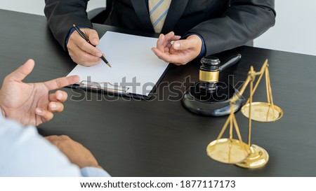 Good service, consultation of male businessmen and male lawyers or judge advisors, with team meetings with clients, legal concepts and legal services too. Scales and hammers are placed on the table.