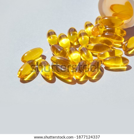 Omega3 gel capsule. Sun shadow. Yellow vitamin. Health eating. Dietology drug. Fish oil supplement. Nurtitional concept. Golden color softgel collagen. Grey background. Medicine immunity cosmetics Royalty-Free Stock Photo #1877124337