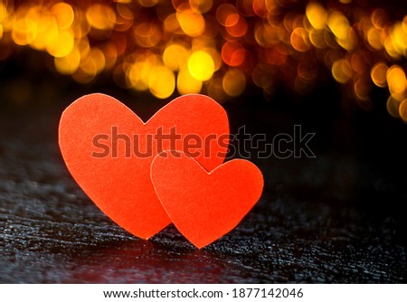 Two red hearts on a background with Golden bokeh. Romantic background.