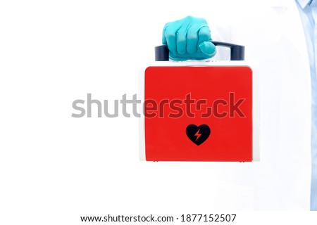 Aed rescue equipment Or a red heart defibrillator In the doctor's hand White background