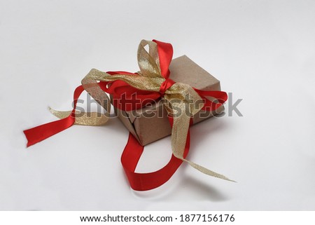 Craft gift box with red and gold ribbon on white background