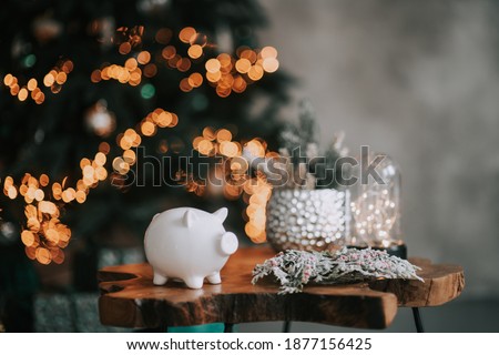 piggy bank in festive New Year atmosphere of scenery. Magical bokeh with Christmas tree and bright lights.
