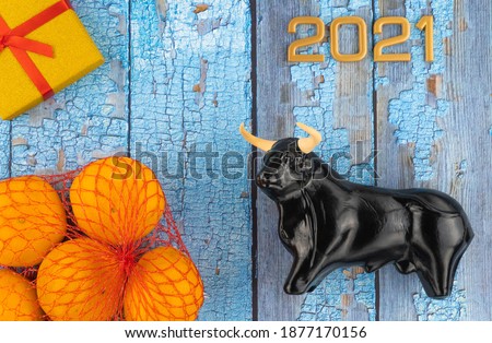 Christmas bull and numbers 2021 on a wooden background. ox, a symbol of the new year according to the Eastern horoscope. wooden boards with scuffed blue paint. 