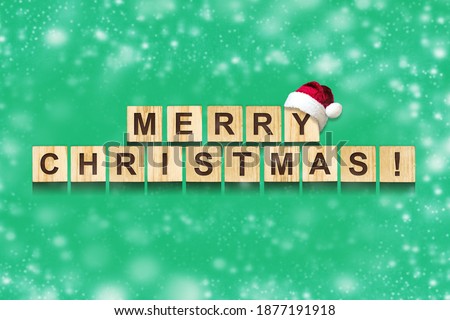 Merry Christmas, Inscription on wooden blocks, on a green background. Snow effect. Christmas background. Festive background.