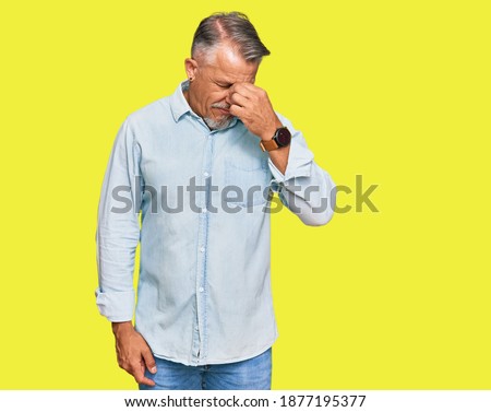 Middle age grey-haired man wearing casual clothes tired rubbing nose and eyes feeling fatigue and headache. stress and frustration concept. 