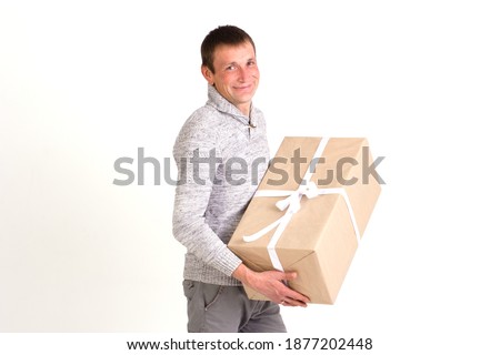 Handsome smiling man with big gift on white background.