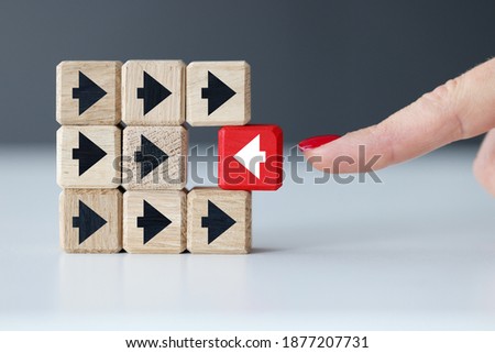 Wooden cubes with black arrows and one red one. Individual approach in business concept Royalty-Free Stock Photo #1877207731