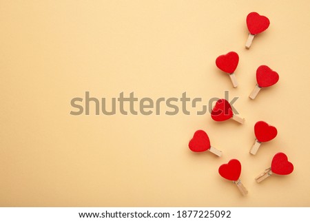 Red Hearts clothespins on beige background. Valentines day concept. Hearts pattern. Top view.