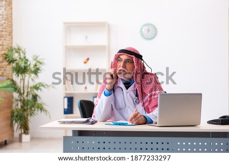 Old male arab doctor working in the clinic