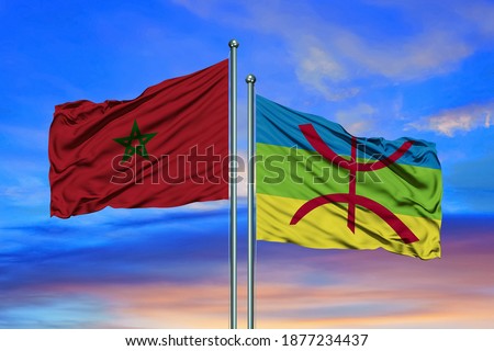 Flag of Morocco and Berbers waving together in the blue sky Royalty-Free Stock Photo #1877234437