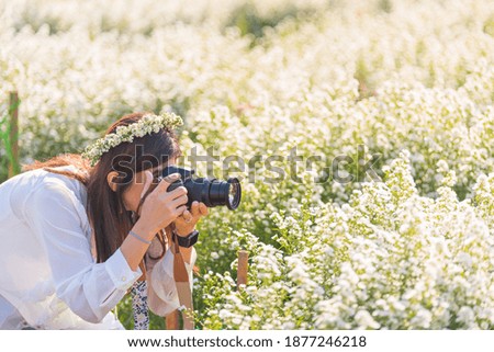 Outdoor lifestyle and hobby photography of a woman travel with Dslr camera in flower garden.