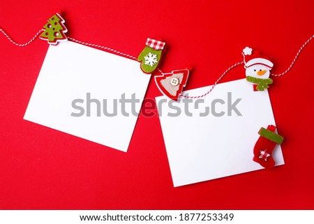 Two blank sheets and festive decorations on a red background. Christmas card. Flat lay style. Empty place