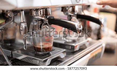 black coffee in measuring cup put on coffee maker