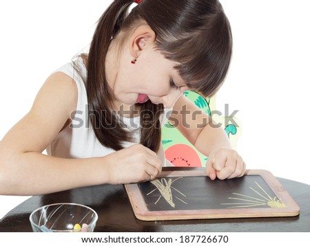 Portrait of young caucasian girl drawing picture by crayons in the chalkboard isolated on white
